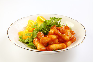 Sliced pork braised with oranges on white dish