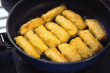 Frying Vietnamese spring rolls in black pan