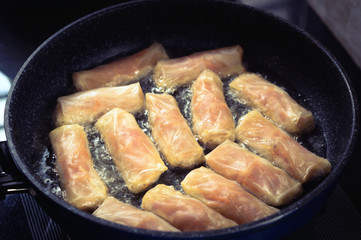 Frying Vietnamese spring rolls in black pan