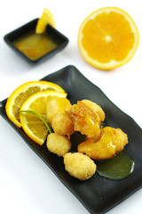 Fried chicken balls with orange sauce on black platter