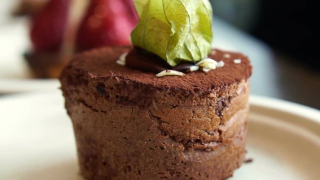 Close up texture lava dark chocolate cake with cape gooseberry topping serve in bakery