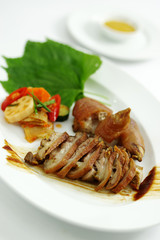 Grilled pig's legs with lotus and kimchi on white platter