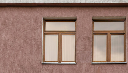 Two windows on a brown wall