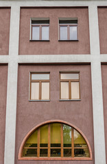 Brown wall with arched window and columns