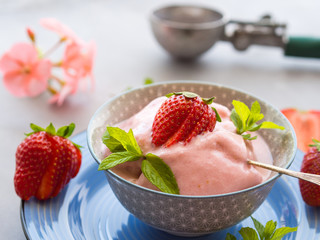 Home made strawberry ice cream in bowl with min leaves