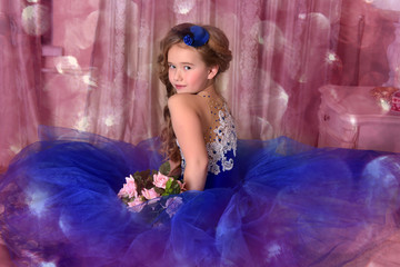 Young princess in a blue evening dress with roses and a little blue hat