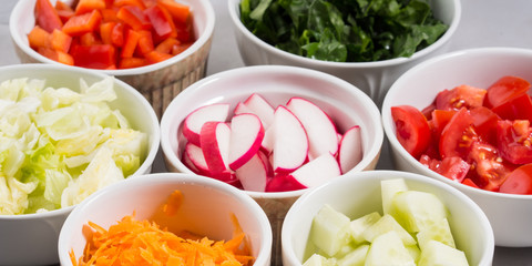 Mix of vegetable bowls for salad or snacks on gray background. Diet detox concept