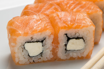 delicious rolls with salmon and ginger on a white plate in a restaurant