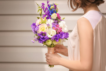 Woman holding bouquet of beautiful flowers
