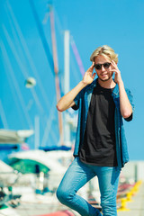 Blonde man standing near harbor in summer