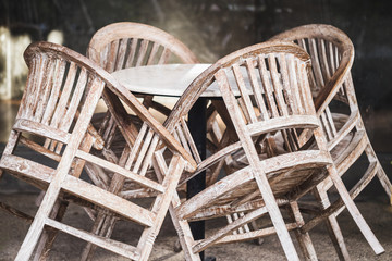 Closed cafe early in the morning. Folded wooden vintage chairs and round tables