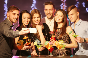 Friends taking selfie at party in night club