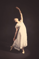 Fototapeta premium Young beautiful ballerina on dark background