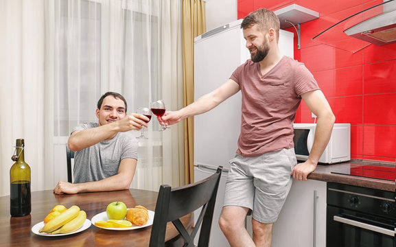 Gay couple drinking wine in kitchen