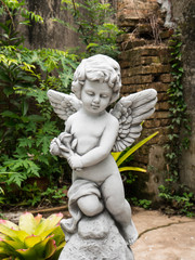 Fototapeta na wymiar Little cupid statue in the garden