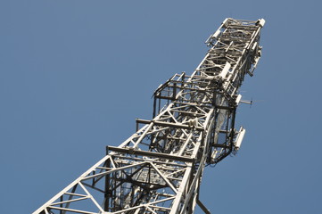 Telecommunication towers with antennas on clear blue sky