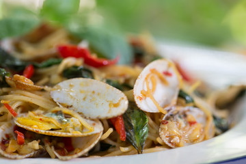 Stir fried Clams and Spaghetti with chili paste in white dish  / Blurred and Selective focus .