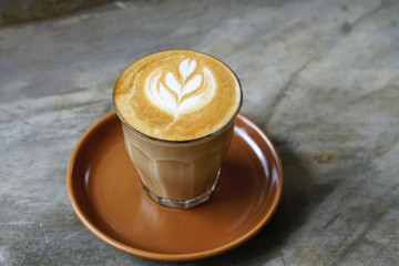Good Morning Coffee Cup - a cup of hot piccolo with latte art on wooden plate with copy space.