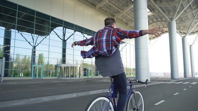 Man in checkered riding a bike with no hands slow motion