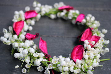 Still-life: a wreath of lilies of the valley on a dark background