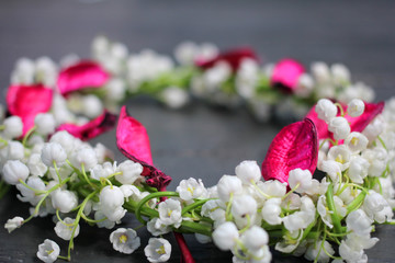 Still-life: a wreath of lilies of the valley on a dark background