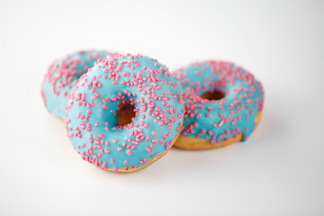 Donuts with blue glaze and pink sprinkles isolated on white background. Top view.