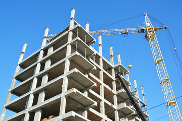 Building cranes on construction site with builders. Building high rise.Crane Construction. Tower Crane and Building Constructors on Construction Site.