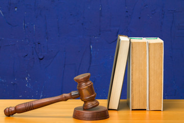 Wooden gavel and books on wooden table