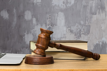 Wooden gavel and books on wooden table