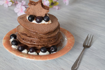 Stack of chocolate pancakes with blueberries toppings