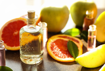 Perfume bottles and fresh fruits on table