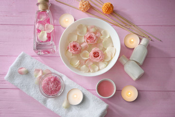 Obraz na płótnie Canvas Beautiful spa composition of flower petals with water in bowl and candles on wooden background