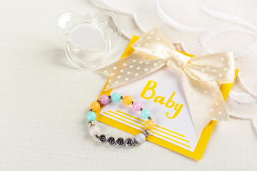 Composition with baby name bracelet on white fabric background