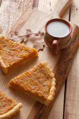 Fresh Homemade Pumpkin Pie made for Thanksgiving. Pie on a wooden background. Rustic.