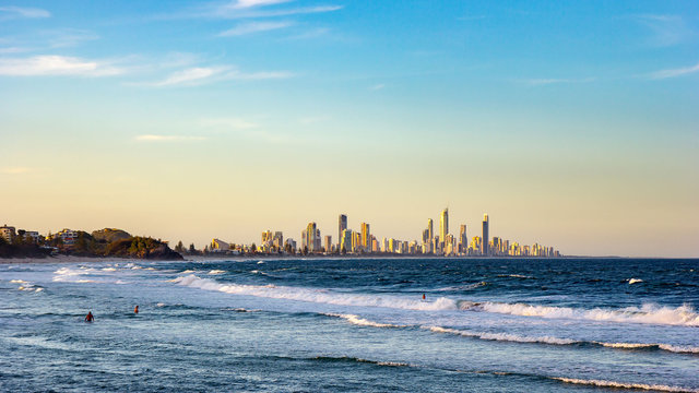 Surfers Paradise waterfront skyline with famous Q1 skyscraper from beach at Sunset. Modern cityscape beach landscape wave in Summer. Surfers Paradise city in Gold Coast region of Queensland, Australia