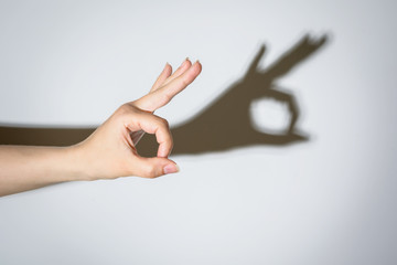 Shadow of a hand making an Okay symbol