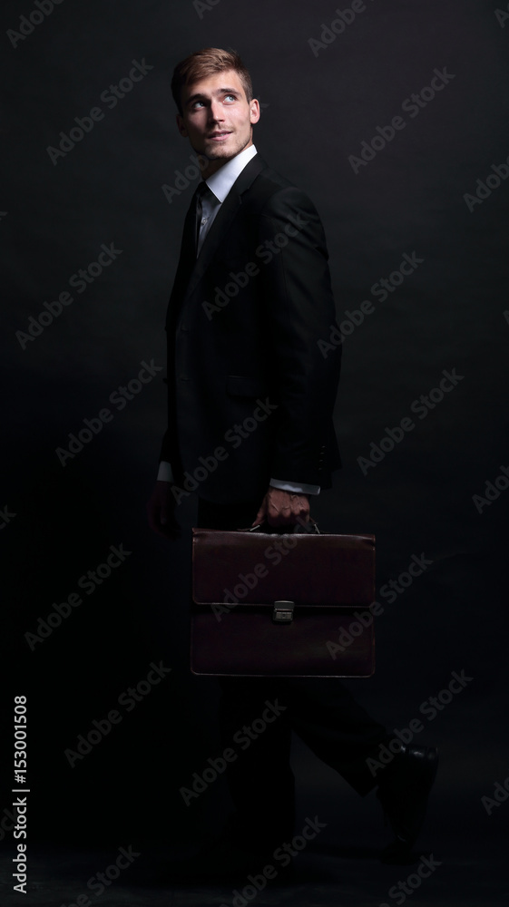 Poster Happy business man wearing black suit isolated on black