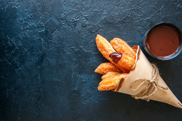 Traditional spanish treat. Popular street food - Churros sprinkled with sugar and cinnamon served...