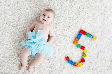Adorable baby girl on white background wearing turquoise tutu skirt. © Irina Schmidt