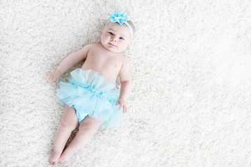 Adorable baby girl on white background wearing turquoise tutu skirt. © Irina Schmidt