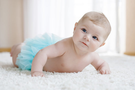 Adorable baby girl on white background wearing turquoise tutu skirt.