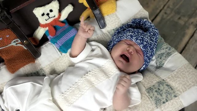Baby in knitted hat. Infant is crying. Loud voice of new generation.