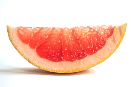 Closeup of a grapefruit wedge on a white background