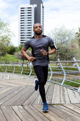 Fit and sporty young man running in the city.