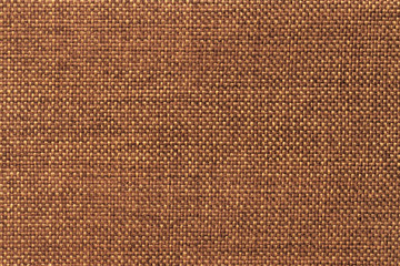 Dark orange background of dense woven bagging fabric, closeup. Structure of the textile macro.