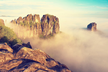 Misty valley, sharp rocks gentle cut creamy fog to strips. Long deep valley full of fresh spring mis © rdonar