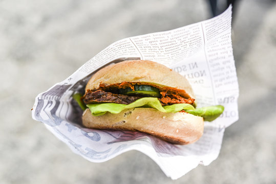 Vegetarian burger in paper, outdoor.