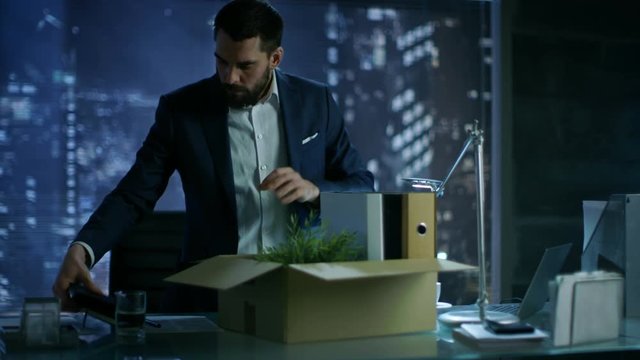 Bankrupt Businessman Collects His Stuff in a Cardboard Box and Prepares to Leave His Company. In Background Big City Window View. Shot on RED EPIC-W 8K Helium Cinema Camera.