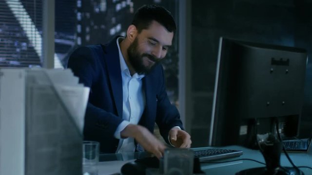 Late at Night Businessman Looses Temper and Hits His Monitor With Keyboard.Shot on RED EPIC-W 8K Helium Cinema Camera.