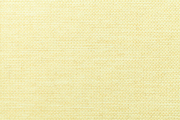 Light yellow background of dense woven bagging fabric, closeup. Structure of the textile macro.